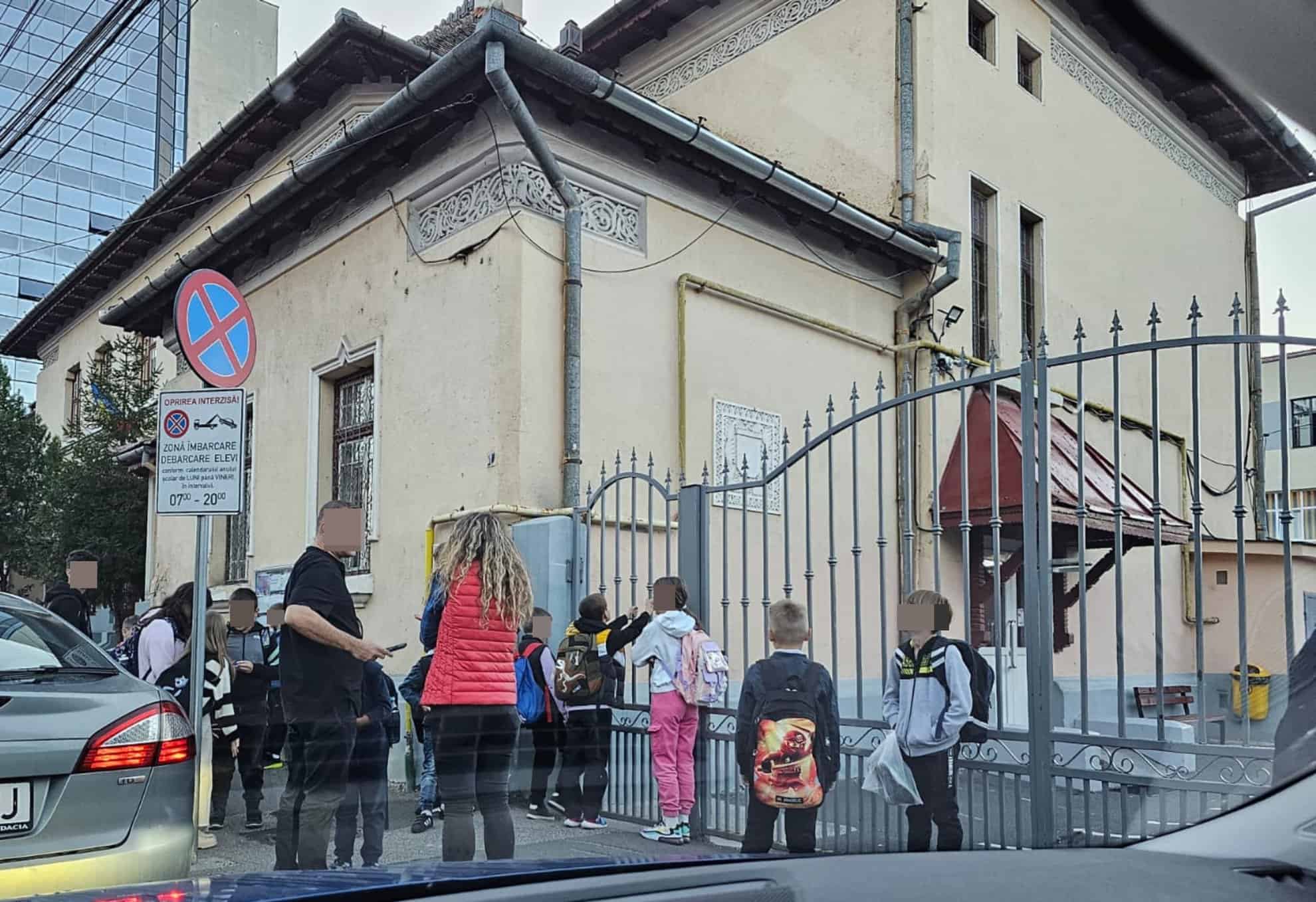 Elevi cu ghiozdane la poarta Școlii Gimnaziale Regina Maria din Sibiu