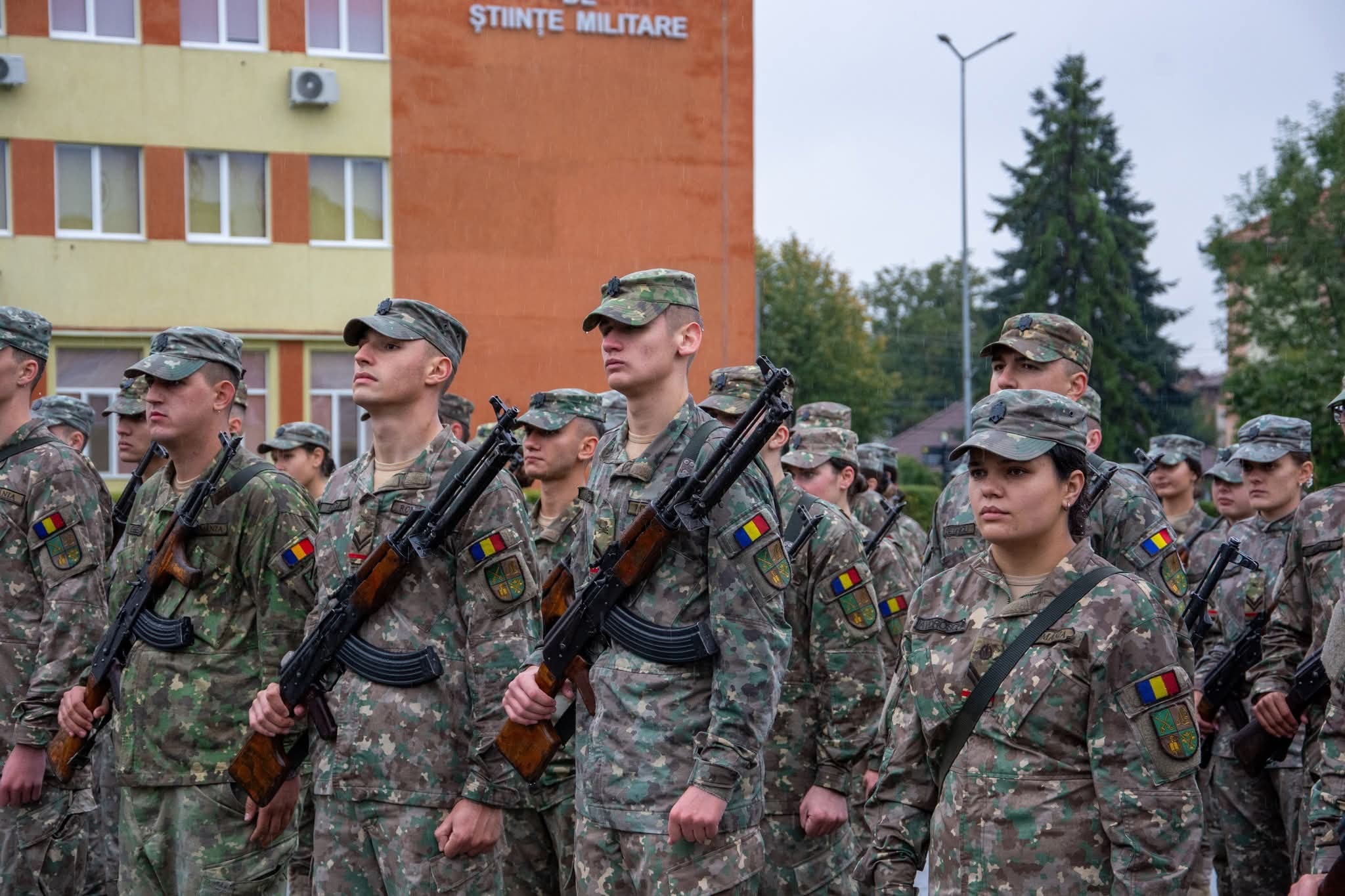 Soldații în uniformă militară cu arme în mână, parada militară în Sibiu, corpul militar român, armata română, defilare militara, în fața clădirii ridicolu științele militare, imagine de la festivalul militar în Sibiu.