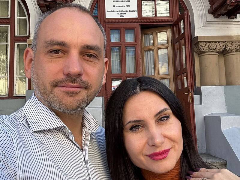Avat naționale care îi arată pe doi oameni fericiți în fața unui clădire istorică din Sibiu, simbol al culturii și istoriei locale, cu detalii arhitecturale tradiționale.