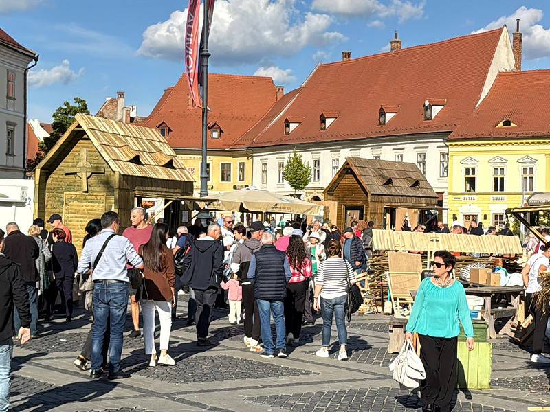 Tâlcuri de lemn în Piața Mare din Sibiu, eveniment tradițional și atrăgător pentru turiști și localnici, parte din Festivalul Rădăcini, promovând cultura și meșteșugurile locale.