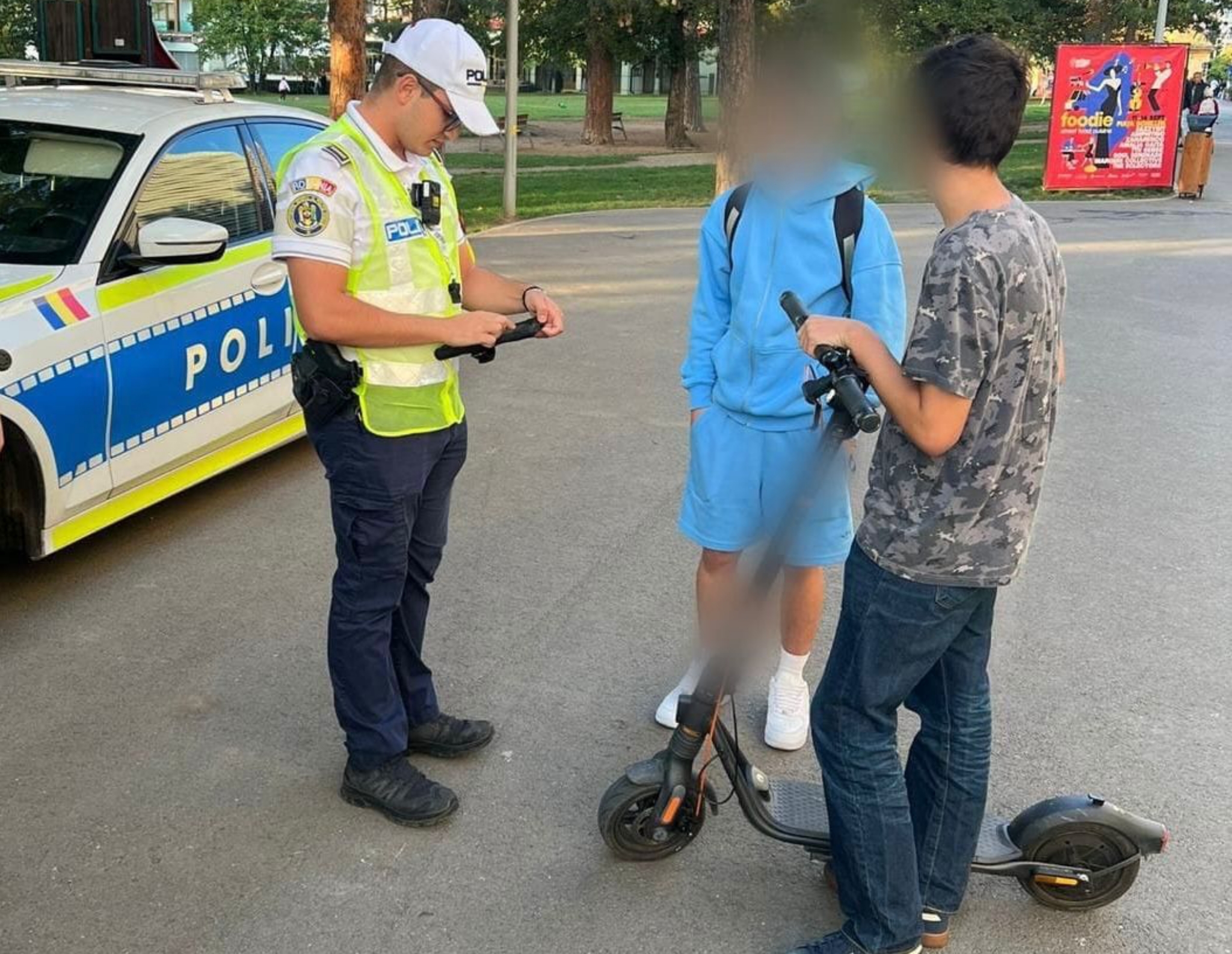 Polițist verificând un adolescent cu trotineta electrică în centru orașului Sibiu, eveniment rutier, siguranța pietonilor, prevenirea infracțiunilor, Poliția Sibiu, acțiuni de patrulare și control.