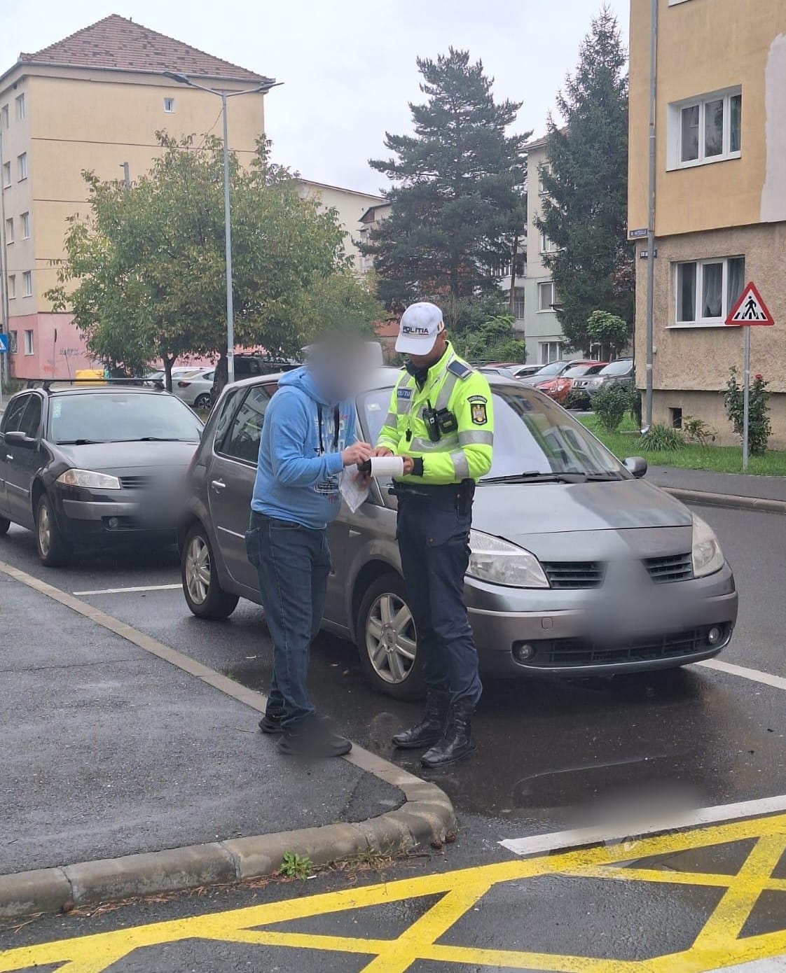 Polițist verificând documentele unui șofer pe strada din Sibiu, în timpul unei acțiuni de control rutier.