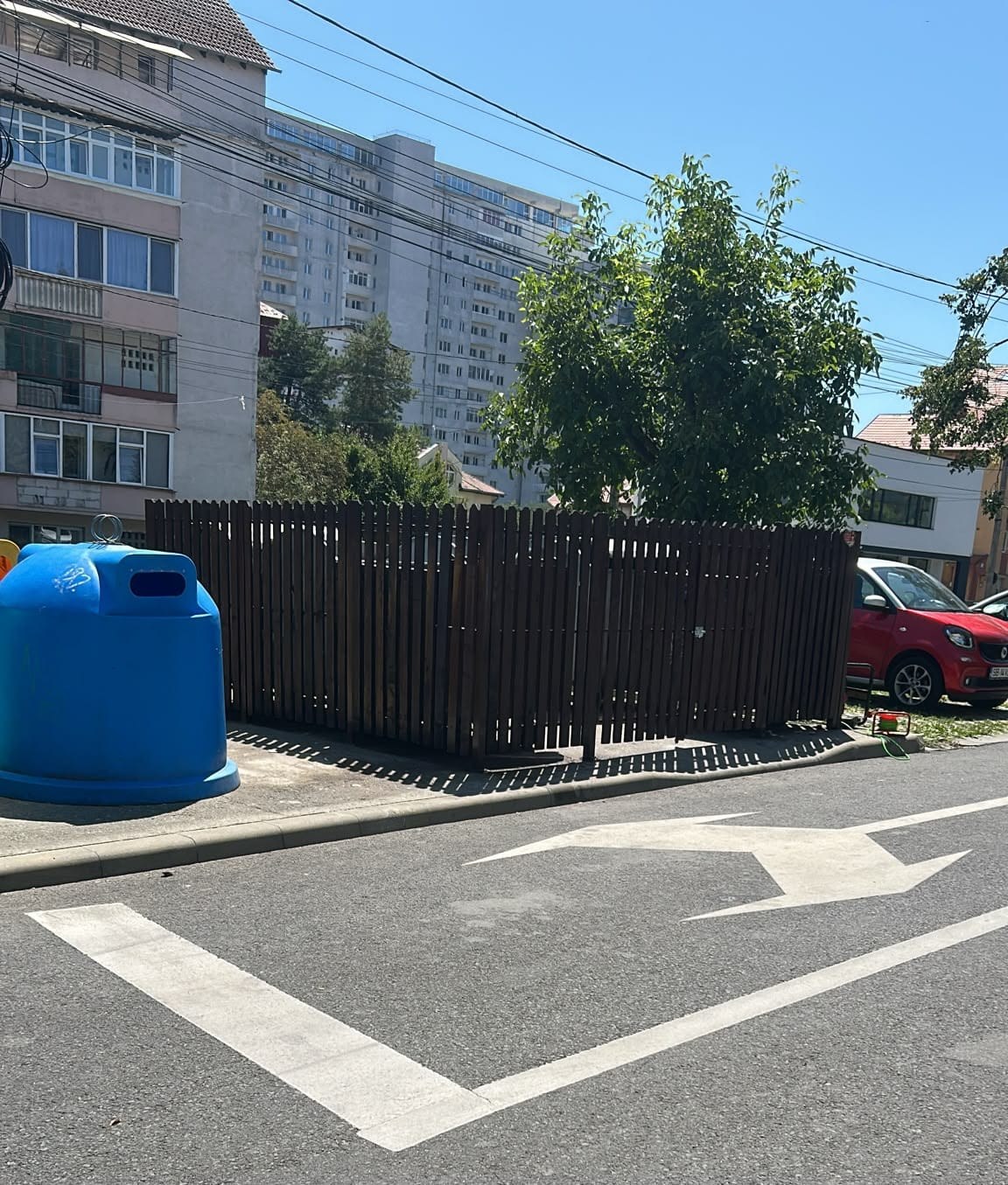 Platformă de gunoi pe colț de stradă, într-un cartier de blocuri din Sibiu, cu containere verde pentru sticlă și galben pentru plastic și metal