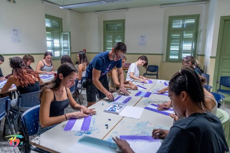 Copii desenând la mese lungi, în timpul unui atelier al Teatrului Gong